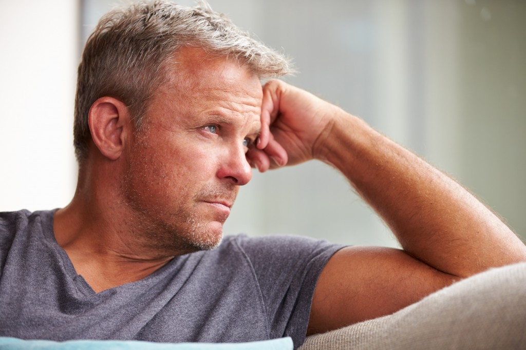 Man looking out into distant clearly suffering from some internal pain